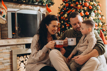 Family enjoying warm drinks during christmas holiday at home