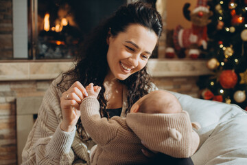 Mother holding baby during christmas holidays at home