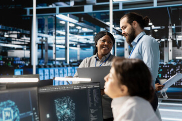 Team of engineers in data center integrating AI driven automation tools, doing maintenance. Teamworking colleagues in server room using artificial intelligence machine learning models