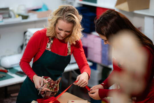 Women gift wrapping christmas presents with friend
