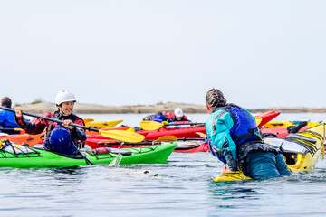 Two female sea kayakers practice rescue techniques during a guide training program on Georgian Bay, Ontario, Canada. room for text