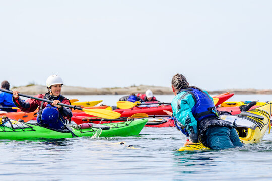 Two female sea kayakers practice rescue techniques during a guide training program on Georgian Bay, Ontario, Canada. room for text
