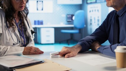 Female healthcare professional uses an oximeter to measure the oxygen levels for patient at check up, accurate medical advice for recovery. Monitoring pulse and saturation with tool. Camera A.