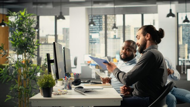 Business staff in modern office sharing insights and reports with colleagues, team focuses on data visualization for efficient resource allocation. Company administration at workplace.