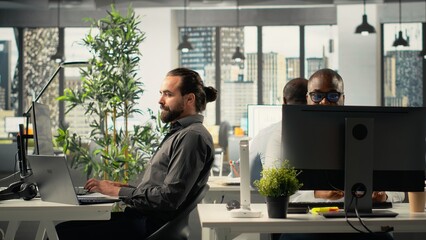 Professional coworkers and managers engaged in report sharing and data visualization. Multiethnic team uses forecasting, analytics, and documentation to strengthen business strategy.