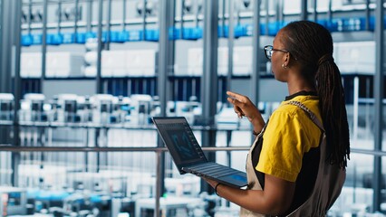 Naklejka premium Engineers in industry 4.0 industrial plant controlling automated machinery, ensuring workflow continuity. Technicians in smart factory managing robotic arms and conveyor belts, camera A