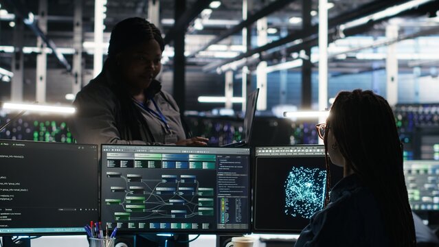 Data center manager supervising technician using node tree software to analyze datasets. Server room team leader oversees IT expert using visual programming tools to improve gear performance, camera B - Powered by Adobe