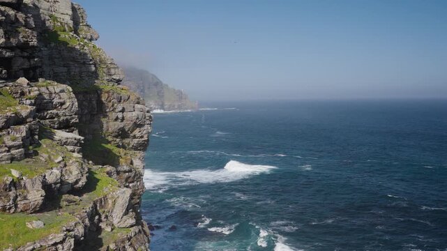 View of Cape Point from the Cape of Good Hope with the upper lighthouse shrouded in mist, which is why the lower one was built. Table Mountain National Park. Cape Town. Western Cape. South Africa.: