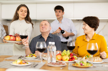 Happy family having dinner together at the festive table at home