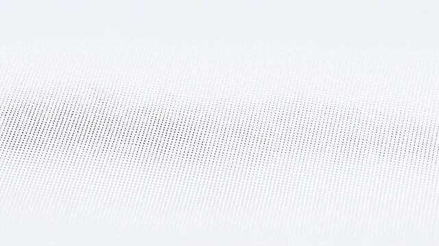 A close-up view of a textured white fabric surface with tiny perforations.