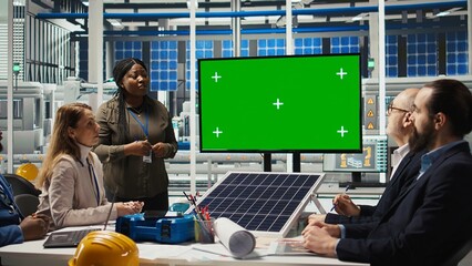 Management executives look at automation strategies for solar panel production scaling on green screen monitor. Businesspeople in factory do financial investments, looking at mockup display, camera A