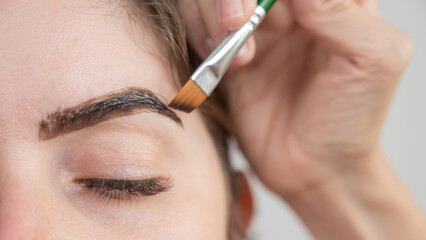 Caucasian woman getting eyebrow tinting procedure. 