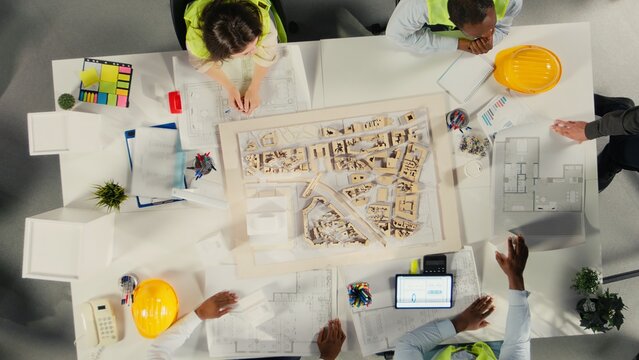 Top down view of colleagues in architecture working together on project design and development. The diverse staff focuses on urban planning, and sustainable property investment. - Powered by Adobe