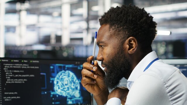 Data center programmer uses neural networks node tree program to identify equipment issues. Server hub employee reviewing AI deep learning data analysis graph to minimize failures, camera B