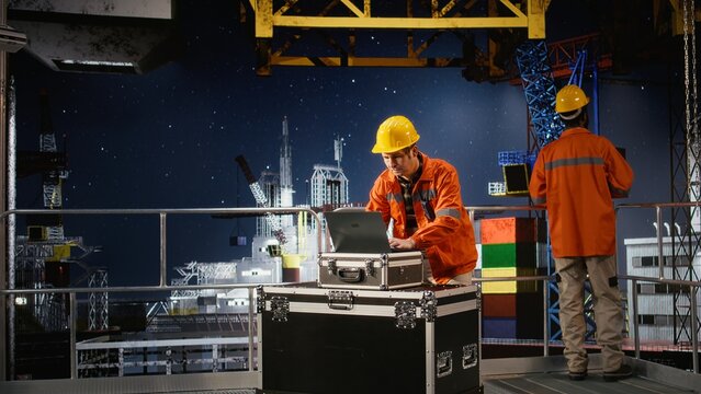 Concerned employee on offshore oil platform manages petroleum extraction using laptop, sweating and struggling to ensure safe oil extraction. Worried restless engineer.