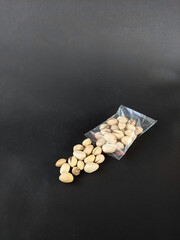 Packaged in plastic pistachio nuts on black background