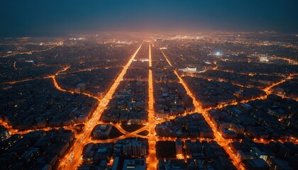 Obraz premium Aerial view of city grid at night. Illuminated streets glow like circuit board in dark metropolis. Urban landscape shows energy data, traffic network. Cityscape extends to glowing horizon under