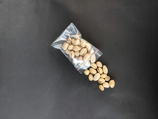 Packaged in plastic pistachio nuts on black background