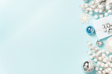 Silver ornaments, white gifts, and festive decorations arranged along the top of a light blue background.