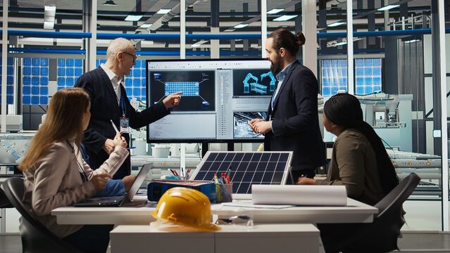 Photovoltaics plant coworkers brainstorming ways to improve solar cells efficiency. Solar panels factory research and development department staff members working on clean energy solutions, camera A