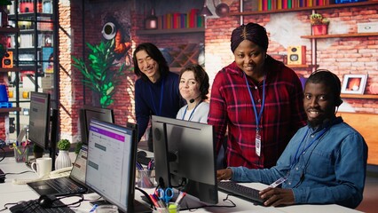 Portrait of smiling multiethnic call center agents helping customers regain access to accounts. Happy multiracial workers in diverse customer center assisting clients needing help, camera B