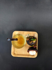 mangosteen fruit (Garcinia mangostana) served with a drink made from its peel extract
