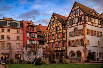 Christmas decorations on half timbered houses in Colmar, France glow at sunset
