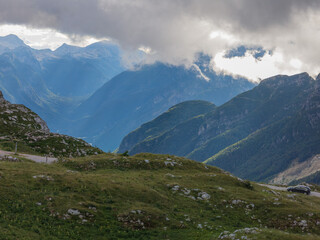 Epic alpine mountains landscape of the Mangart massive rugged cliffs with atmospheric light from the cloudy sky 