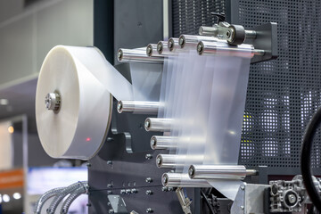 Industrial plastic film extrusion machine with multiple rollers, reels and transparent film, showing the advanced production equipment for efficient production of plastic packaging