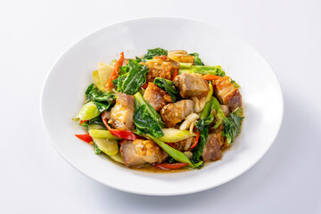 Stir fried kale with crispy pork in oyster sauce on white plate
