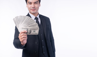 Successful handsome businessman in black suit holding a fan of one hundred US dollar bills showing wealth and profit.Happy professional man with cash money isolated on white background with copy space