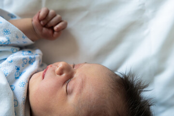 Newborn infant sleeping peacefully on hospital crib
