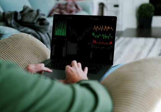 Middle Aged Day Trader Moving Around Downstairs of Home While Working Daily Trades on Stock Market Concept - Powered by Adobe