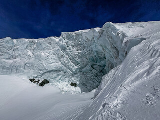 Steep alpine glacier wall and rugged snowy ridge near Zermatt, Switzerland. Crisp winter light highlights the icy textures and dramatic mountain landscape in the Swiss Alps.