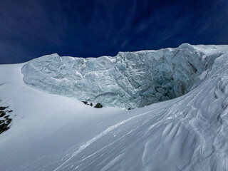 Steep alpine glacier wall and rugged snowy ridge near Zermatt, Switzerland. Crisp winter light highlights the icy textures and dramatic mountain landscape in the Swiss Alps.
