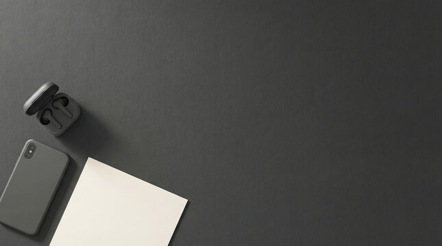 Minimalist black flat lay workspace with a smartphone, wireless earbuds in case, and a blank white paper note on a dark gray background