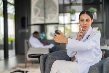 Female doctor using smartphone for remote work, conducting video call consultation to provide health advice and telemedicine services for patient, online medical care, diagnosis and treatment