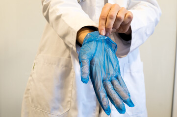 Close-up of Hands Carefully Peeling Off a Disposable Blue Glove, Infection Control Protocol