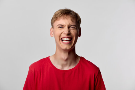 Laughing, smile, man, red shirt, joy, happiness, expression, upbeat, energy, casual moment of a young man captured in a bright, joyful mood, perfect for lifestyle or marketing content seeking - Powered by Adobe
