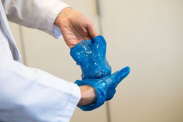 Hands of a Healthcare Provider During the Critical Stage of Glove Doffing Procedure.