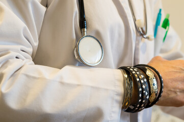 Medical Misconduct Concept, Doctor's Bracelet-Covered Wrist and Stethoscope Against White Coat