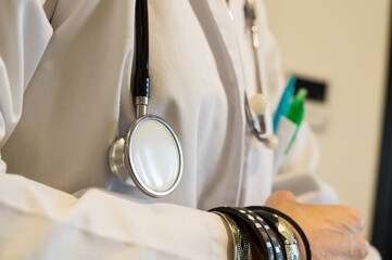 Unsanitary Medical Practice, Doctor's Arm with Bracelets Near Stethoscope, Infection Control Concern