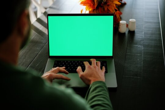 Mature bearded man working remotely on customizable green screen laptop- Perfect for inserting your own app, dashboard, video call, charts, or website - Powered by Adobe