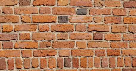 Old weathered red brick wall texture, rough masonry surface background, historic building facade detail. Construction material, orange clay bricks pattern, abstract backdrop, closeup, nobody