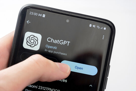 OpenAI ChatGPT official app page on Google Play Store, hand pressing the open button closeup. Artificial intelligence chatbot software, mobile smartphone interface, white background, one person