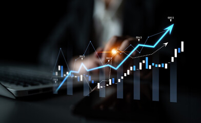 A businessman analyzes financial data on a laptop, surrounded by visual graphs and charts in a dark...