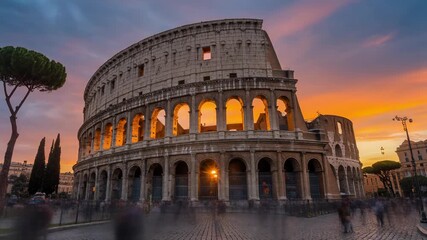 The ancient Roman Colosseum bathed in the warm glow of a vibrant sunset, with blurred people in the foreground. - Powered by Adobe