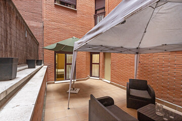 Obraz premium Modern urban terrace with wooden deck flooring, modular outdoor sofa, and vertical garden with integrated LED lighting