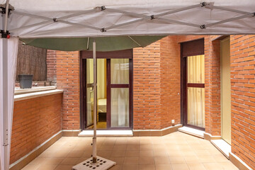 Obraz premium Minimalist terrace with porcelain tile flooring, a decorative water feature, and contemporary designer furniture in neutral tones