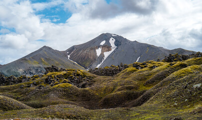 Iceland travel - Bl&aacute;hnj&uacute;kur mountain and old moss covered Lava field in the foreground in Landmannalaugar